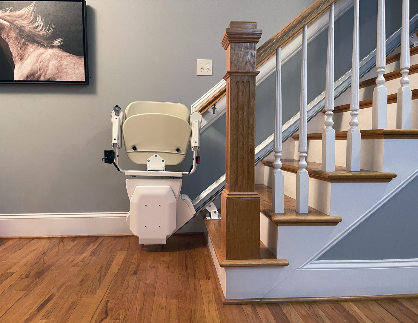AmeriGlide straight stairlift installed on an oak staircase with white risers